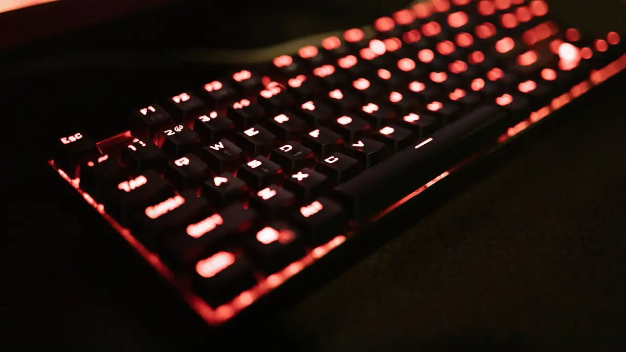 Teclado mecánico con retroiluminación roja brillando en la oscuridad